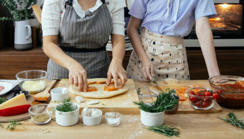 two women in aprons cooking together