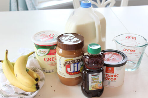 Ingredients used to make smoothies: milk, peanut butter, bananas, cocoa powder, greek yogurt, and honey