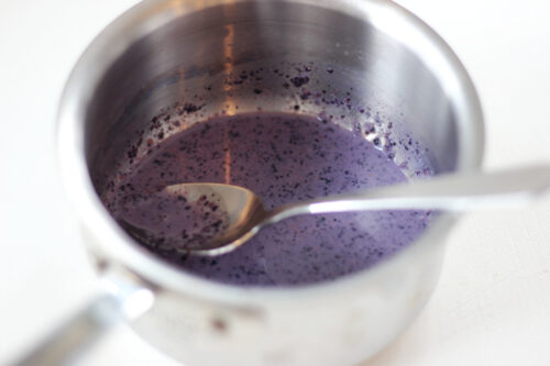 Dried blueberries and milk in saucepan
