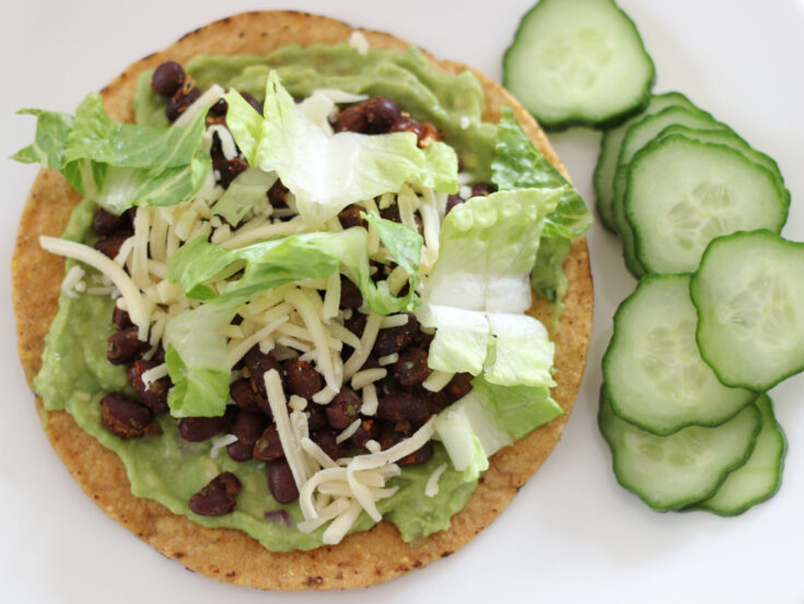 Black bean tostadas with guacamole next to sliced cucumbers