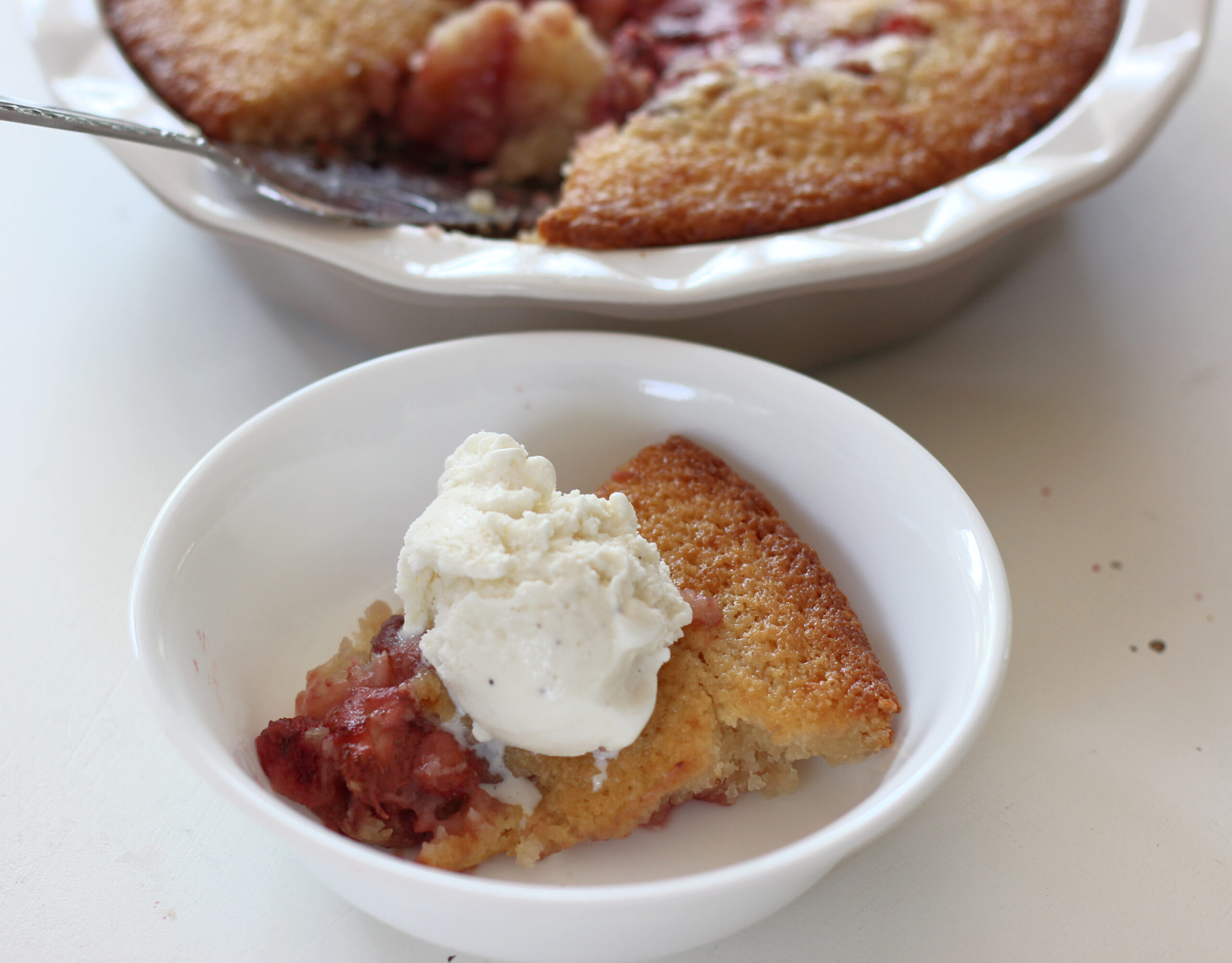 Slice of strawberry cobbler with ice cream