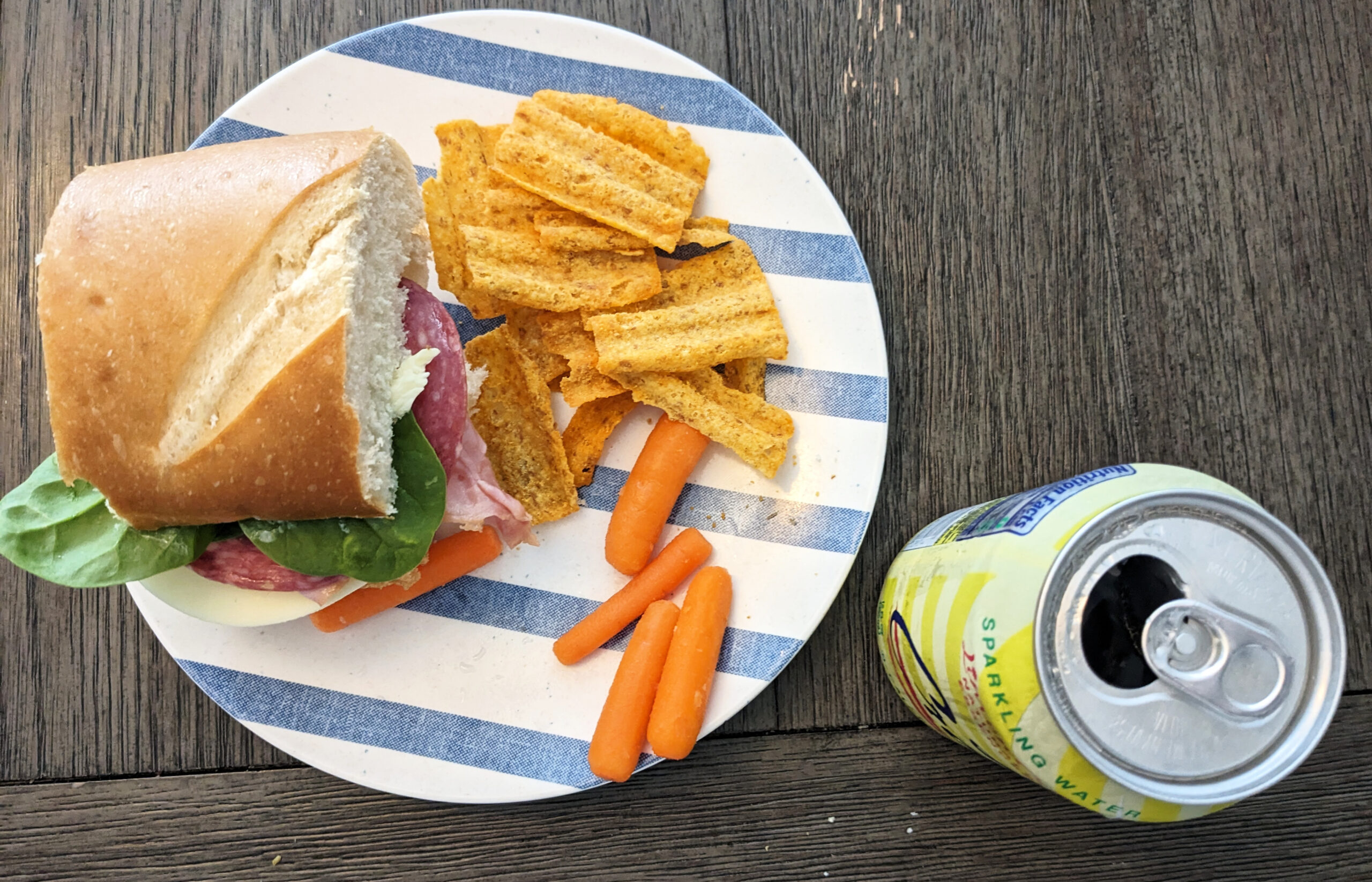 Lunch sandwich with carrots, corn chips and sparkling water